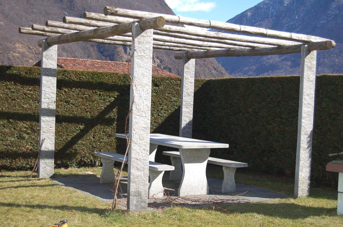 Tessiner Pergola mit Granit Tisch aus Tessiner Gneis. Pergola mit Kastanienholz berdeckt.